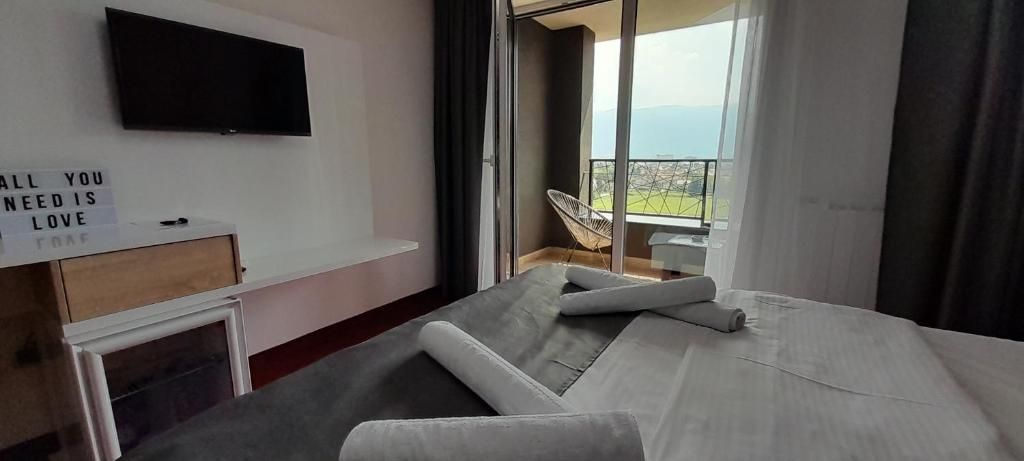 Spavaća soba s televizorom i izlazom na balkon